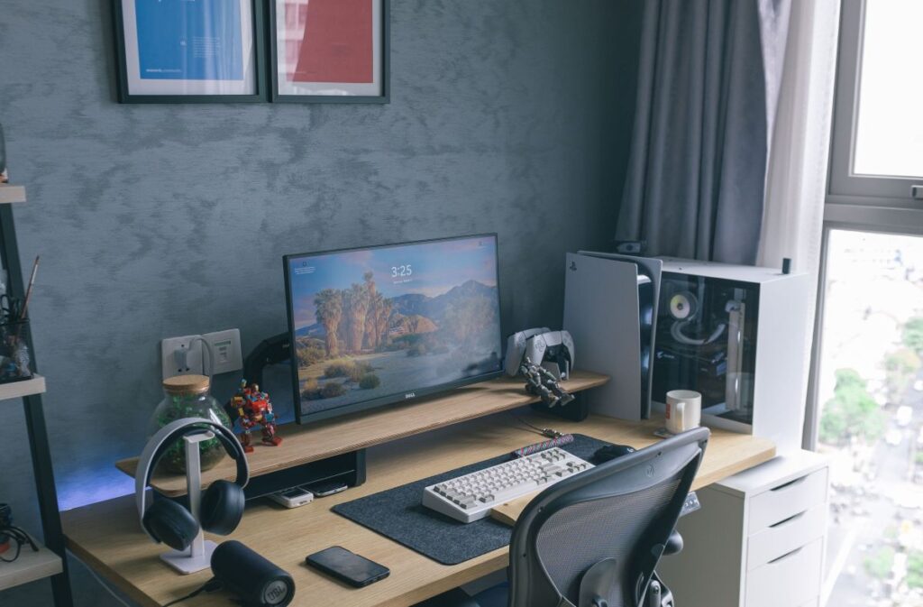 high density narrow tech desk setup with monitor shelf and white storage drawer unit